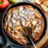 Apple fritter skillet cake topped with caramel glaze and sliced apples in a cast iron pan