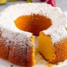 Philly fluff cake recipe featuring a golden, fluffy bundt cake topped with powdered sugar.
