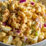 Creamy macaroni salad with eggs, celery, onion, and paprika.