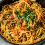 Taco spaghetti recipe easy with ground beef, tomatoes, and melted cheese in one skillet