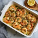 Baked garlic parmesan shrimp topped with golden breadcrumbs in a white baking dish