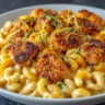 A close-up view of a white bowl filled with creamy honey pepper chicken mac and cheese, topped with crispy chicken bites and garnished with fresh parsley and shredded cheese.