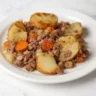 Tennessee Hobo Casserole with ground beef, potatoes, and carrots on a white plate