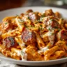 A close-up shot of a white bowl filled with creamy chicken sausage pasta, featuring penne in a rich tomato cream sauce with seared sausage slices, and garnished with fresh parsley.