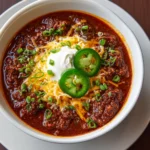 A close-up overhead shot of a white bowl filled with a classic chili recipe