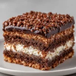 Rich chocolate cake square with crispy chocolate top and cream filling.