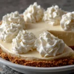 No-bake eggnog pie with graham cracker crust and whipped cream swirls for an easy holiday dessert