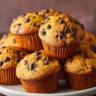 Moist pumpkin muffins loaded with chocolate chips on a rustic plate