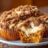 Pumpkin muffins filled with creamy cheesecake and topped with a cinnamon streusel crumb
