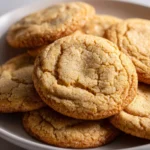 Golden brown sugar cookies with a slightly cracked surface, rolled in sugar and baked until crisp on the edges and soft in the center.