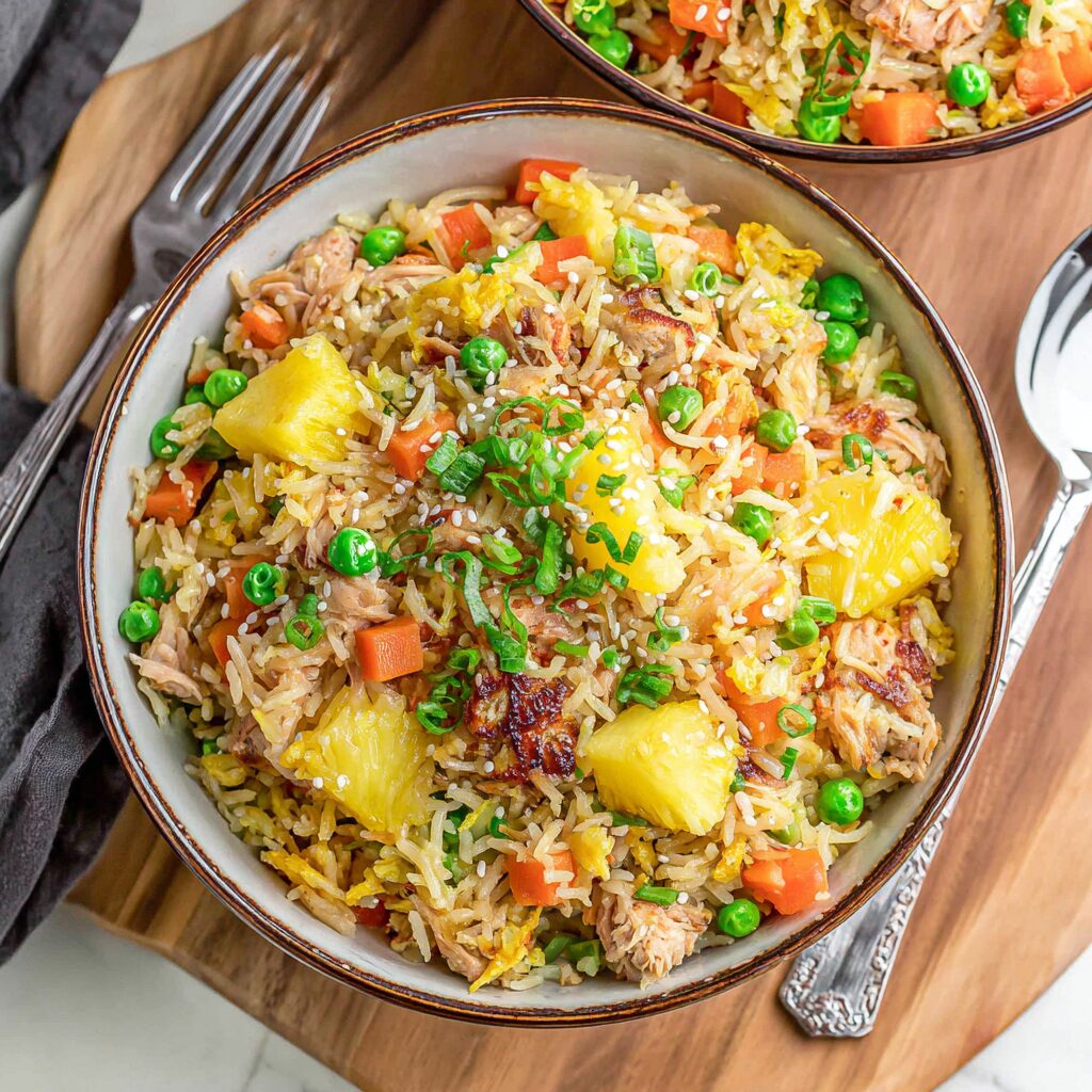 A colorful plate of pineapple fried rice, brimming with tropical fruit, vegetables, and savory rice, tantalizes the taste buds.