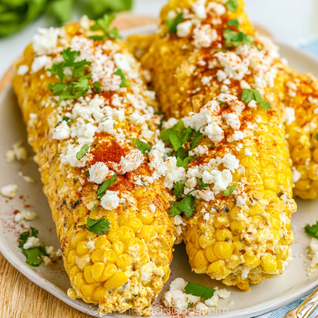 Golden kernels of corn, coated in crema and chili, are pictured in an air fryer basket.