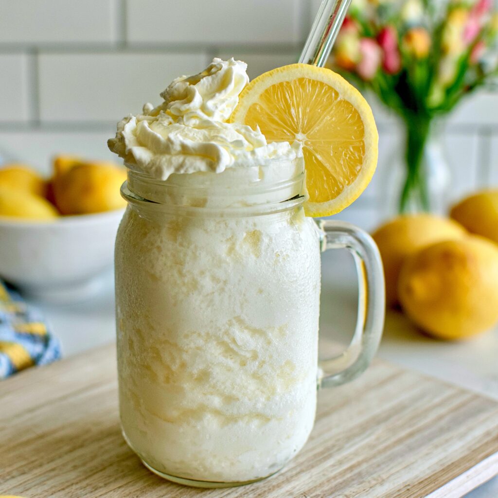 A refreshing glass of creamy, icy whipped lemonade on a bright, sunlit day.