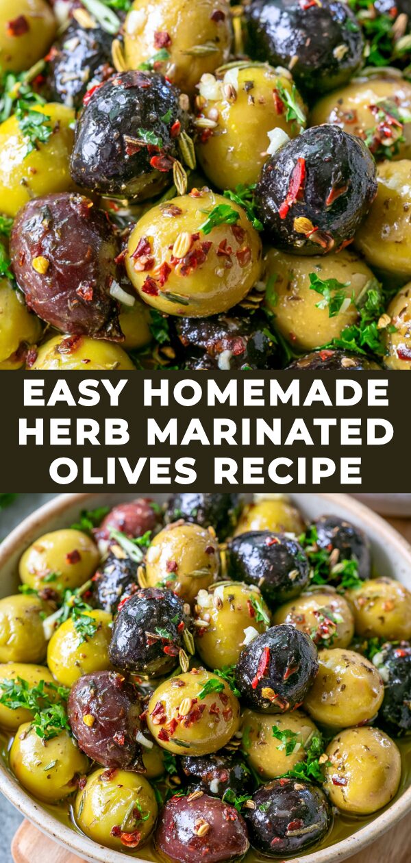 Vibrant green and purple olives marinate in a glass jar with herbs and chili flakes.