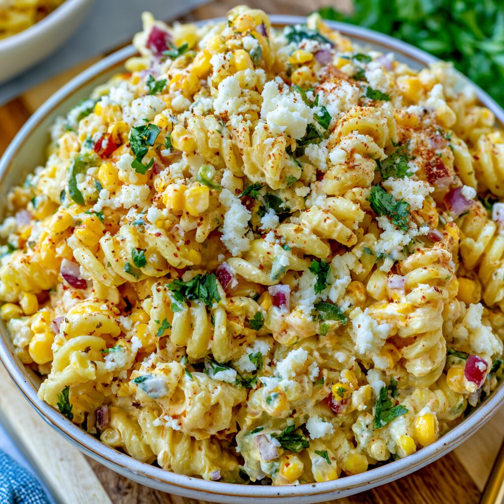 Colorful pasta salad featuring corn, peppers, and cilantro in a creamy dressing.